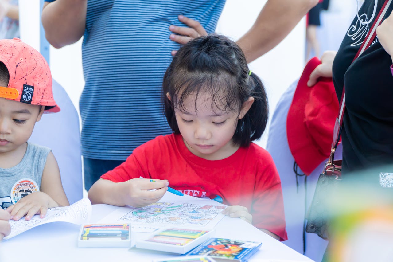 Young children enjoying a coloring activity with crayons at a table, focused and creative.