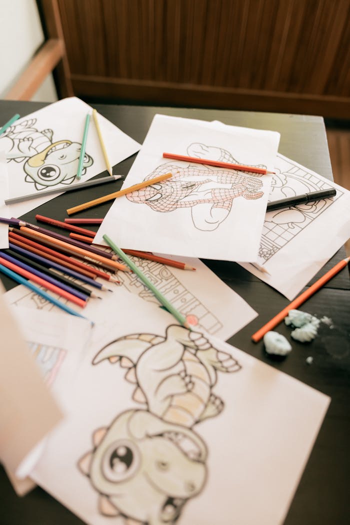 Colorful assortment of kids coloring pages and pencils on a desk, inspiring creativity.